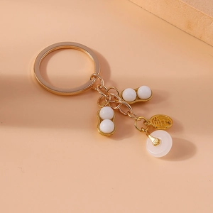 Detailed close-up of golden keychain with faux jade peanuts and fu character pendant
