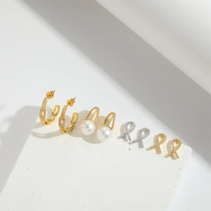 Baroque bow earrings and pearl drop studs set on a minimalist white stone base