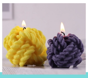 Macro shot of knitted yarn ball candles in yellow and purple with warm lighting
