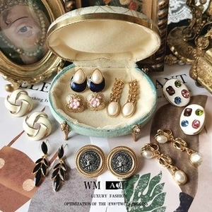 Dettaglio di orecchini vintage con perle e oro in un portagioie a forma di conchiglia