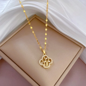 Gold titanium steel clover necklace with crystal inlay on beige box and white silk