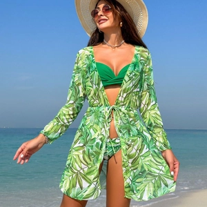 Detail of three-piece green tropical palm leaf bikini set with long-sleeved mesh cover-up