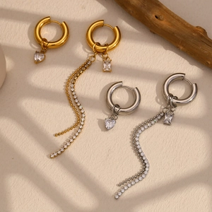 Detail of 18K gold plated asymmetric earrings with heart charms and long tassels