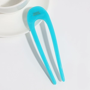 Detail showing a turquoise jelly color U-shaped hair stick with France Handmade engraving