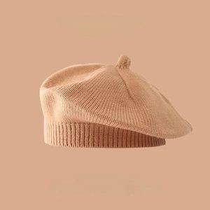 Detailed view of camel knitted wool beret texture with soft fabric and top stem detail