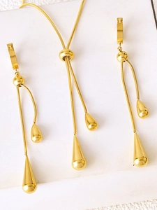 Polished gold water drop pendant necklace and long drop earring jewelry set macro view