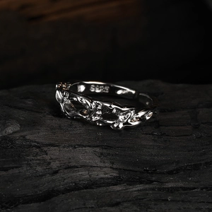 Macro view of S925 sterling silver ring with irregular lava texture on dark wood background