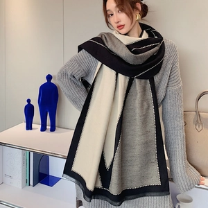 Detail of color-block scarf with V-letter pattern and delicate white stitch borders