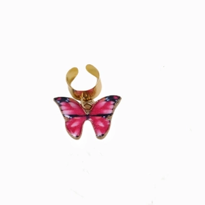 Detailed view of pink and black butterfly charm with golden ring for dreadlocks and hair