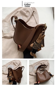 Detailed view of coffee brown half-moon hobo bag with cute rabbit pendant in home setting