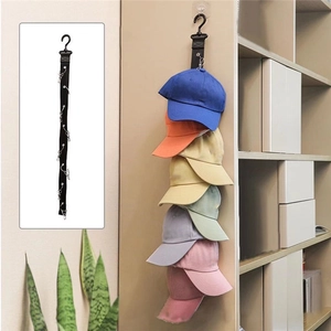 Organizador vertical de gorras con clips metálicos y correa negra en escena de hogar