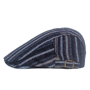 Detail of vintage striped beret with bronze adjustable buckle and thick cotton texture