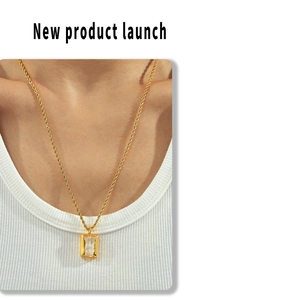 Close-up of a gold twist chain necklace with a rectangular translucent pendant on a model