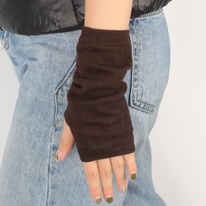 Close-up of dark brown knitted fingerless arm warmers with ribbed cuffs and thumb hole
