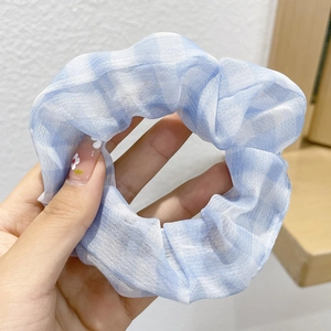 Close-up of light blue plaid scrunchie made of breathable sheer fabric with ruffles