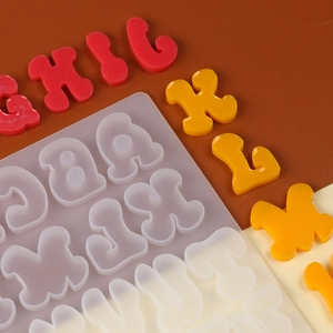 Macro shot of colorful resin alphabet charms alongside a translucent silicone mold