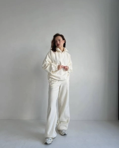 Gros plan sur la texture polaire épaisse et le demi-zip de cet ensemble détente pour femme