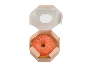 Top view of an orange donut with pink frosting in an octagonal gift box on white background