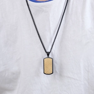 Men's two-tone dog tag necklace featuring a gold hammered texture with black border