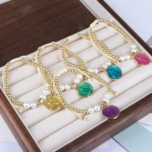 Detail of colorful religious bead bracelets with Virgin Mary charms and golden beads