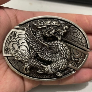 Detailed close-up of antique silver dragon belt buckle with intricate metal carving