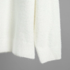 Detail of white plush knit sweater showing ribbed cuffs and side split hem texture