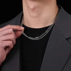 Detail of silver double-layered paperclip and Cuban chain necklace for men in hip-hop style