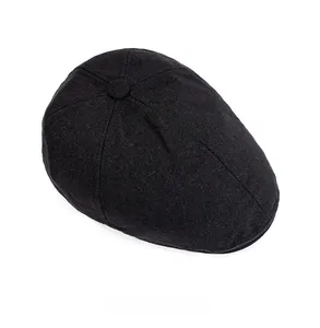 Detail view of the black newsboy hat featuring textured knit fabric and top button