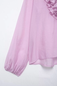 Detail view of light purple blouse showing ruffled design and elastic cuffs texture