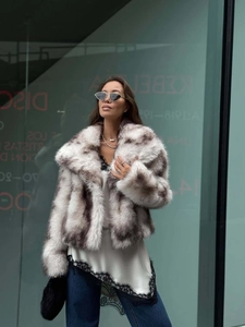 Detail of short faux fur coat with grey and white spotted texture and wide lapel