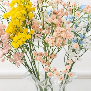 Colorful artificial gypsophila bouquet in glass vase for wedding and home decor