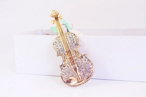 Porte-clés violon doré raffiné avec détails en strass brillants sur boîte blanche