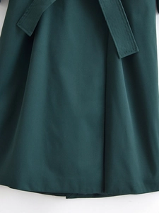 Detail of dark green twill fabric texture and waist belt tie for a trench coat