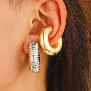 Minimalist gold ear cuff and silver textured hoop earring set shown on a model