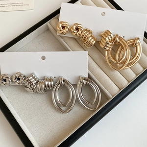 Detail of twisted knot gold and silver hoop earring sets displayed in a gift box