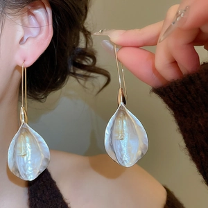 Détail de boucles d'oreilles pétales en argent avec crochets dorés sur mannequin
