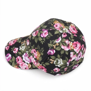 Detailed top view of a black floral baseball cap with pink rose patterns and green leaves