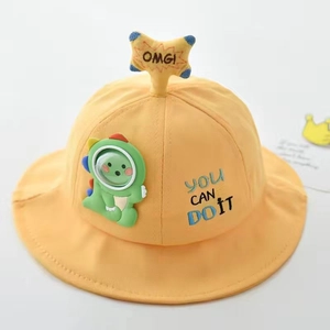 Detail of yellow cotton sun hat for kids featuring cute dinosaur patch and star charm
