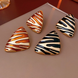 Detailed view of vintage gold-plated triangular earrings with tiger stripe patterns