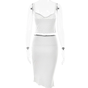 Detailed close-up of a white and black polka dot two-piece set with a crop top and midi skirt