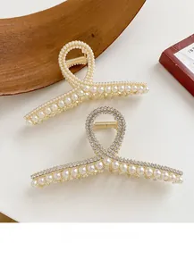 Détail de pinces à cheveux dorées avec perles et strass sur fond vintage élégant