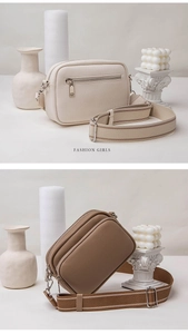 Close-up of retro lychee textured leather crossbody bag with striped fabric strap