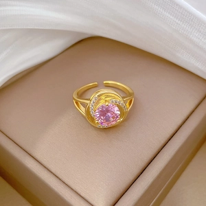 Detail of a gold-plated adjustable ring with pink gemstone and micro-paved crystals