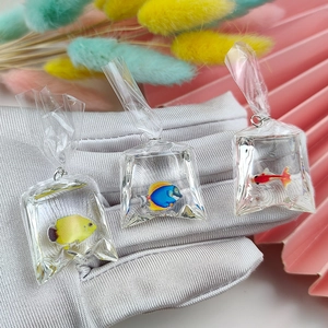 Detail of mini resin goldfish bag charms with colorful fish inside liquid-filled pouches