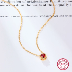 Macro shot of 925 silver necklace with vintage red zircon pendant and white stones