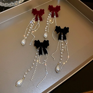 Detail von roten und schwarzen Samtschleifen-Ohrringen mit Perlenquasten und Strass
