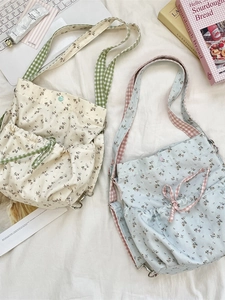 Floral canvas tote bags with plaid straps and drawstring bows in a cozy home setting