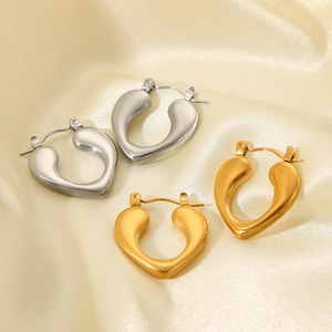 Detailed close-up of gold and silver U-shaped earrings on elegant satin fabric