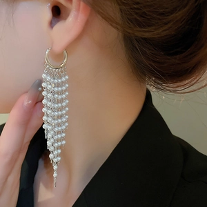 Detail of 18k gold plated long pearl tassel earrings on a model for an elegant look