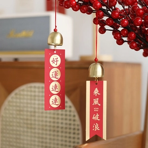 Festive Chinese brass bells with red tassels hanging on branches for home decor